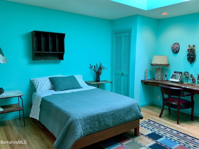 bedroom featuring baseboards and wood finished floors