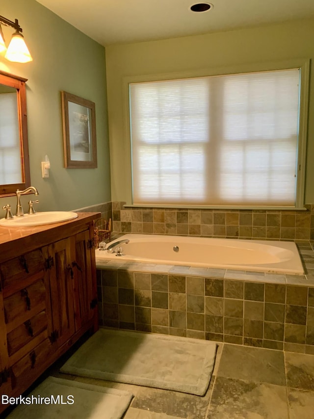 full bathroom with a garden tub and vanity