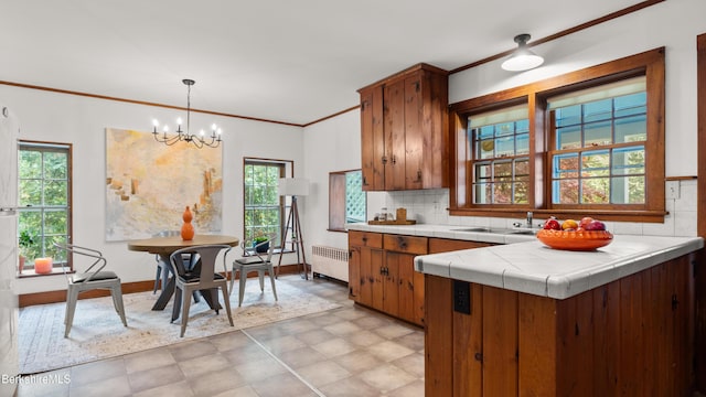 kitchen featuring radiator, tile countertops, healthy amount of natural light, and ornamental molding
