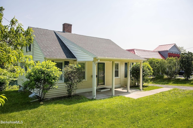 153 State Rd, Great Barrington, MA 01230 - cape cod-style house with a shingled roof, a front lawn, a chimney, and a patio area