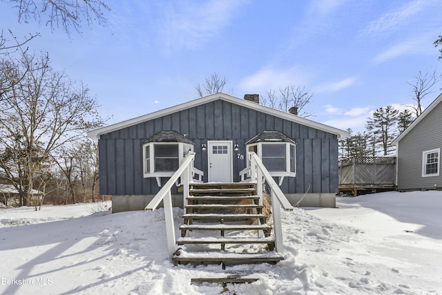 view of front facade with board and batten siding and a chimney