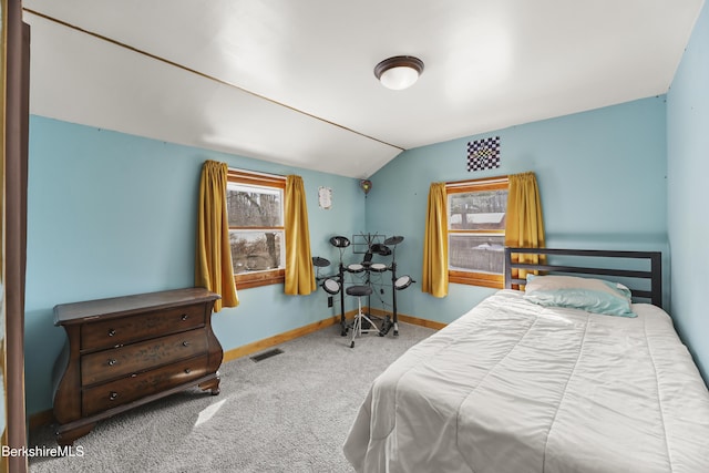 carpeted bedroom featuring lofted ceiling, baseboards, and visible vents