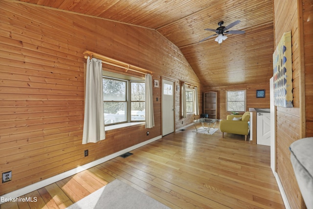 interior space with visible vents, a ceiling fan, wooden ceiling, wood walls, and light wood-style floors