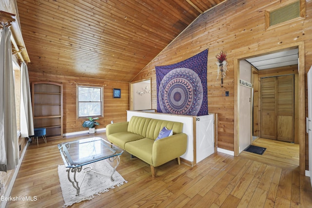 living room featuring light wood finished floors, wood ceiling, wooden walls, and vaulted ceiling