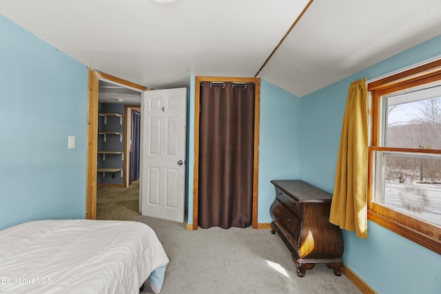 bedroom featuring carpet, vaulted ceiling, and baseboards