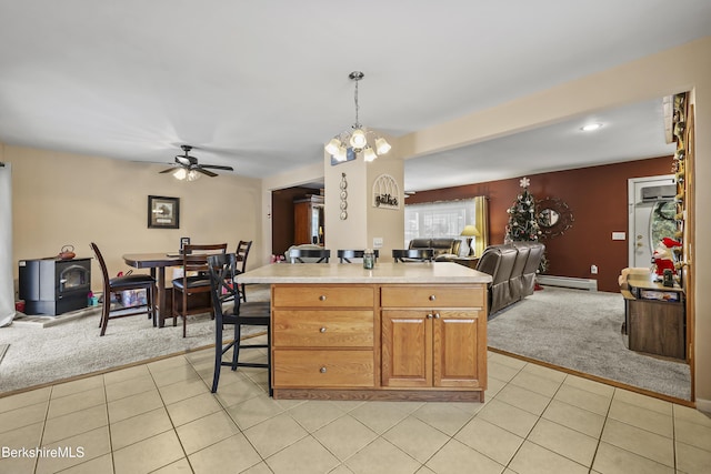 kitchen with a kitchen island, light colored carpet, hanging light fixtures, and a baseboard heating unit