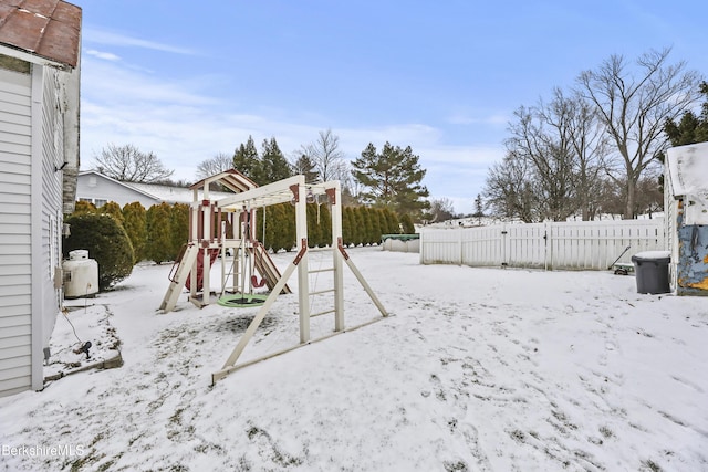 snowy yard featuring a playground