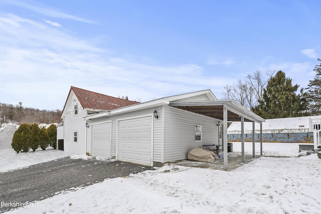 view of snowy exterior with a garage