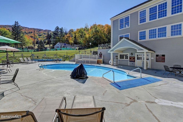 view of pool featuring a mountain view and a patio