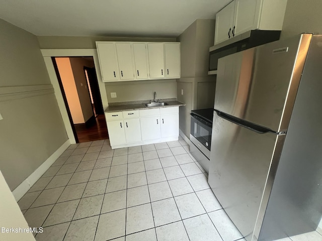 kitchen with sink, stainless steel refrigerator, electric range, white cabinets, and light tile patterned flooring