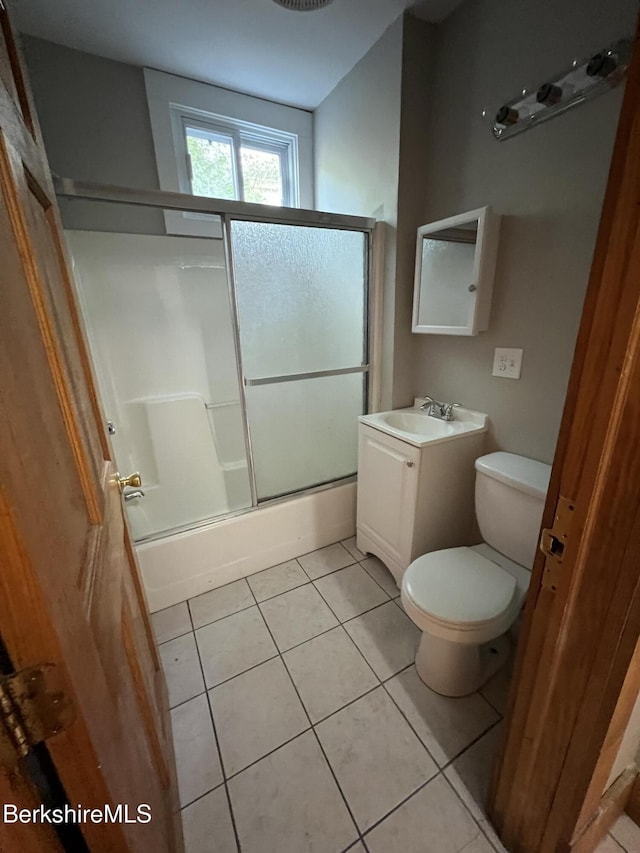 full bathroom featuring vanity, combined bath / shower with glass door, tile patterned floors, and toilet