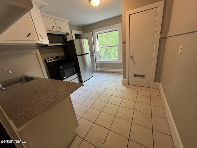 kitchen with white cabinetry, stainless steel appliances, light tile patterned flooring, and sink