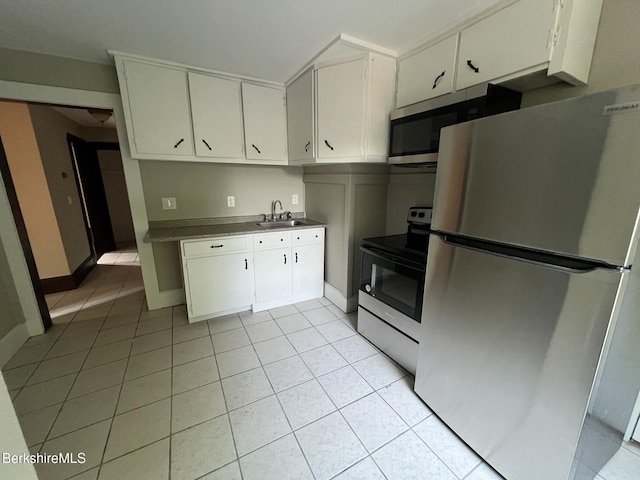 kitchen featuring stainless steel appliances, sink, light tile patterned floors, and white cabinets