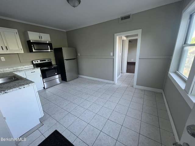 kitchen featuring white cabinetry, appliances with stainless steel finishes, sink, and light tile patterned floors