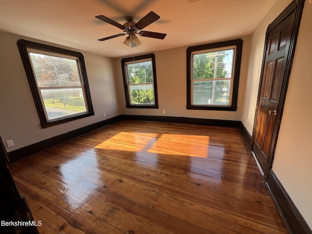 empty room featuring dark wood-type flooring and ceiling fan