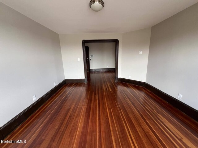 spare room with dark wood-type flooring