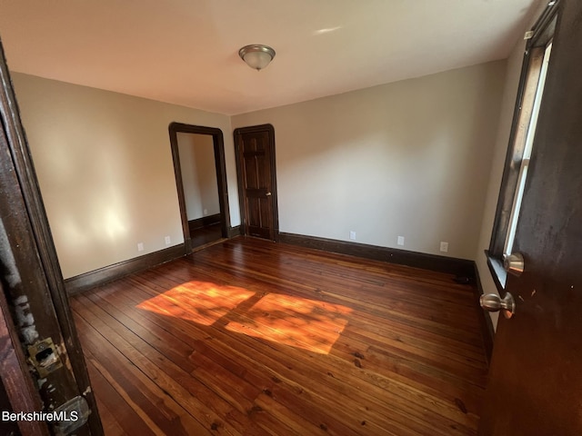 spare room with dark wood-type flooring