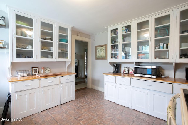 6-10 Manville St, Great Barrington, MA 01230 - kitchen with stainless steel microwave, glass insert cabinets, white cabinetry, and butcher block countertops