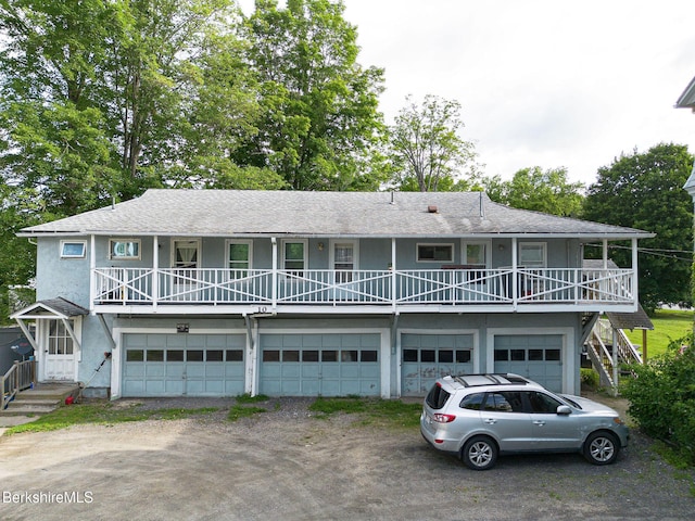 6-10 Manville St, Great Barrington, MA 01230 - view of front of house with a garage, driveway, stucco siding, and roof with shingles
