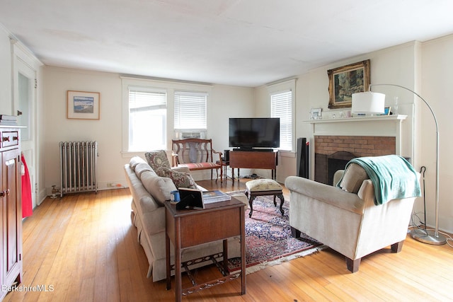 6-10 Manville St, Great Barrington, MA 01230 - living area featuring radiator, light wood-style flooring, and a brick fireplace