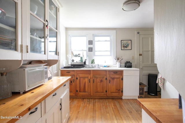 6-10 Manville St, Great Barrington, MA 01230 - kitchen featuring wood counters, light wood finished floors, white microwave, glass insert cabinets, and brown cabinetry