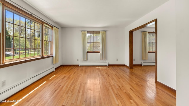 unfurnished room featuring a baseboard radiator, light wood-style flooring, and a baseboard heating unit
