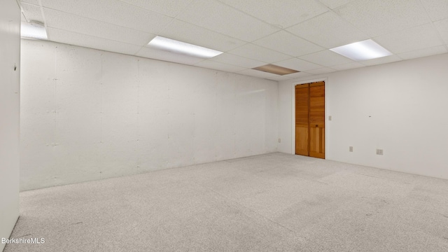 carpeted empty room with a drop ceiling