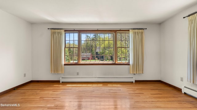 unfurnished room featuring a baseboard radiator, light wood finished floors, baseboards, and baseboard heating