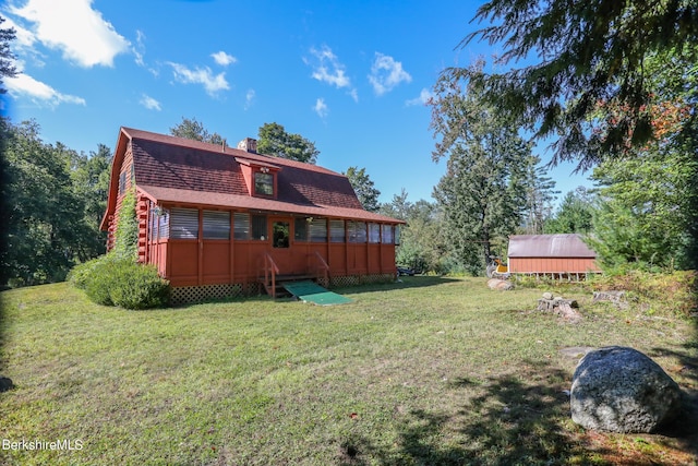 rear view of property with a lawn