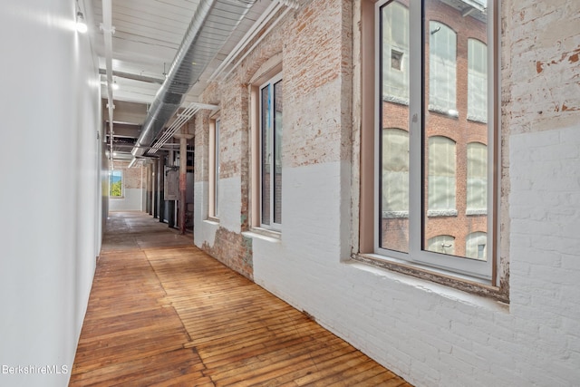 hallway with a towering ceiling and brick wall