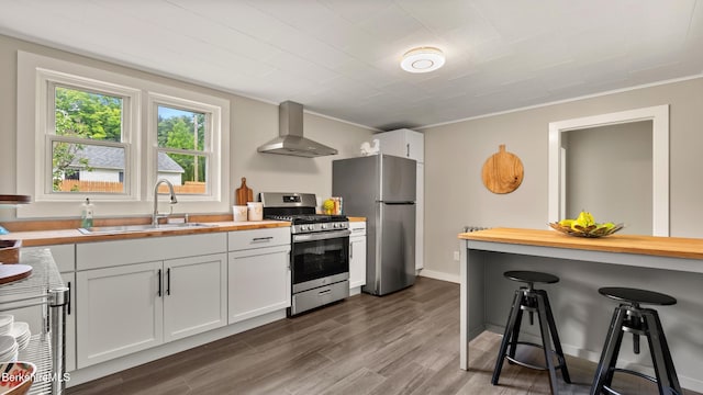 370 Park St, Great Barrington, MA 01236 - kitchen with stainless steel appliances, wall chimney range hood, wood counters, a kitchen bar, and dark wood finished floors