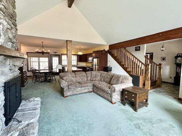 791 Partridge Rd, Lanesborough, MA 01237 - carpeted living area with high vaulted ceiling, stairs, a stone fireplace, a chandelier, and beamed ceiling