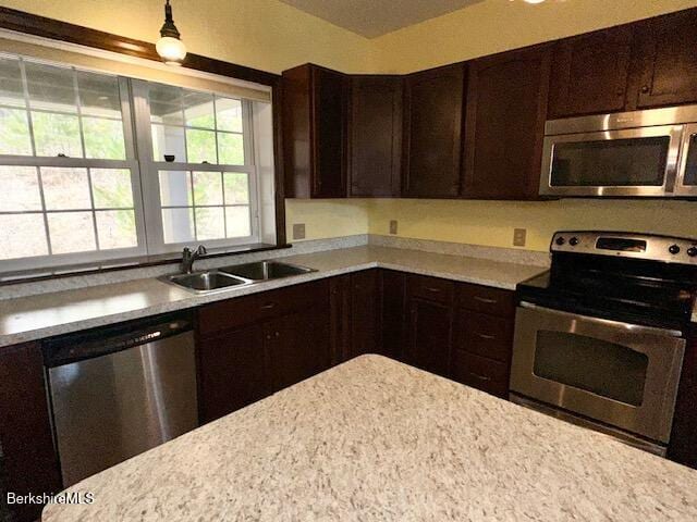 791 Partridge Rd, Lanesborough, MA 01237 - kitchen featuring appliances with stainless steel finishes, a sink, light countertops, dark brown cabinetry, and hanging light fixtures