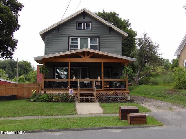 view of front of home with covered porch and a front lawn