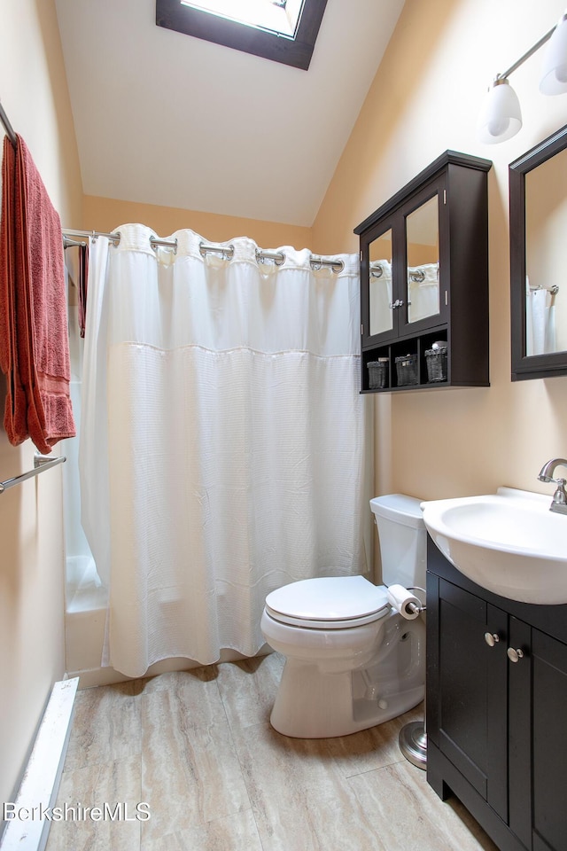 bathroom with vaulted ceiling with skylight, vanity, wood finished floors, toilet, and shower / tub combo with curtain