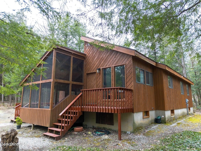 rear view of house with a deck and a sunroom