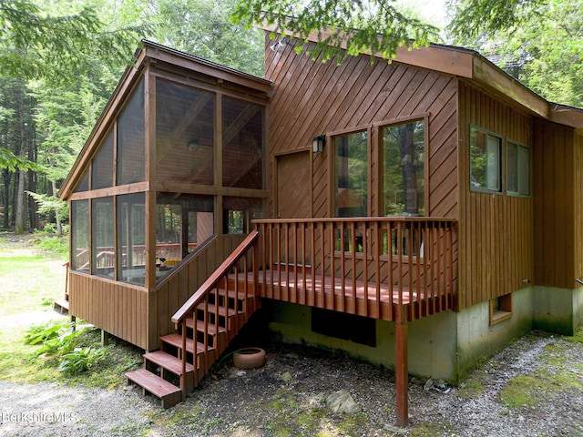 309 Tamarack Trl, Sandisfield, MA 01255 - back of property featuring a sunroom, a deck, and a wooded view