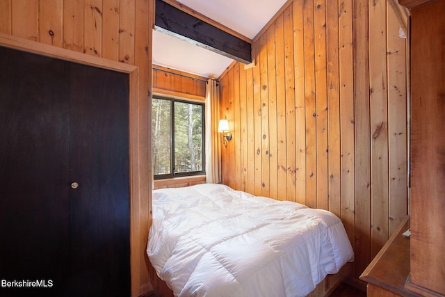 bedroom featuring wooden walls