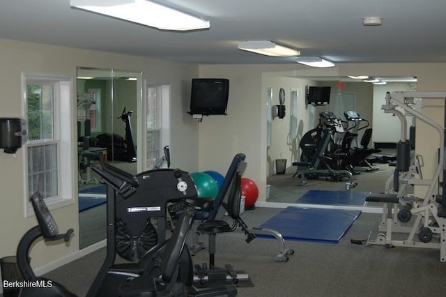 workout area featuring baseboards and plenty of natural light