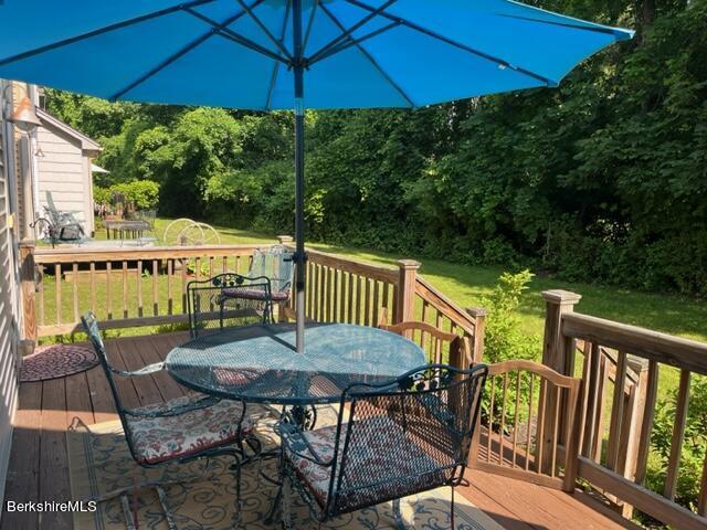 8 Stanley Dr Unit A-4, Great Barrington, MA 01230 - wooden terrace with outdoor dining area, a lawn, and a view of trees