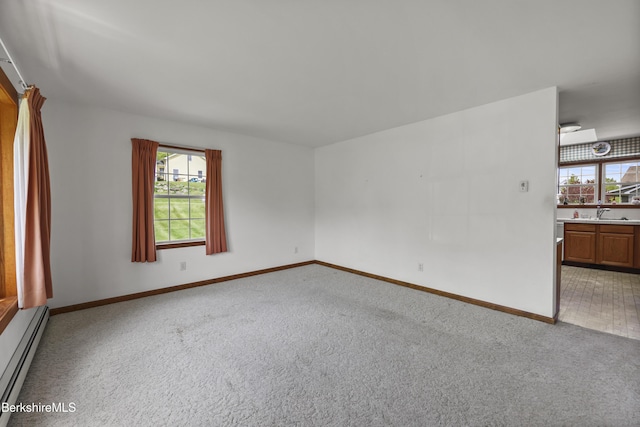 120 Via Maria St, Lee, MA 01238 - empty room featuring baseboard heating, light carpet, baseboards, and a sink