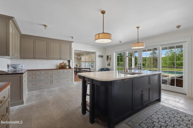 1030 W St, Pittsfield, MA 01201 - kitchen with tasteful backsplash, an island with sink, hanging light fixtures, a breakfast bar, and ornamental molding