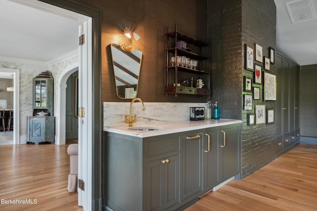 1030 W St, Pittsfield, MA 01201 - indoor wet bar featuring arched walkways, light wood-style floors, crown molding, tasteful backsplash, and wallpapered walls