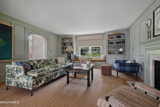 1030 W St, Pittsfield, MA 01201 - living room featuring a decorative wall, built in shelves, arched walkways, and a premium fireplace