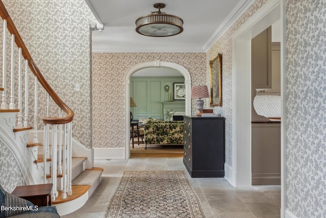 1030 W St, Pittsfield, MA 01201 - foyer entrance with wallpapered walls, stairway, crown molding, light tile patterned flooring, and arched walkways