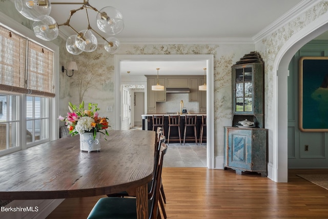 1030 W St, Pittsfield, MA 01201 - dining space featuring a chandelier, arched walkways, wallpapered walls, light wood-type flooring, and crown molding