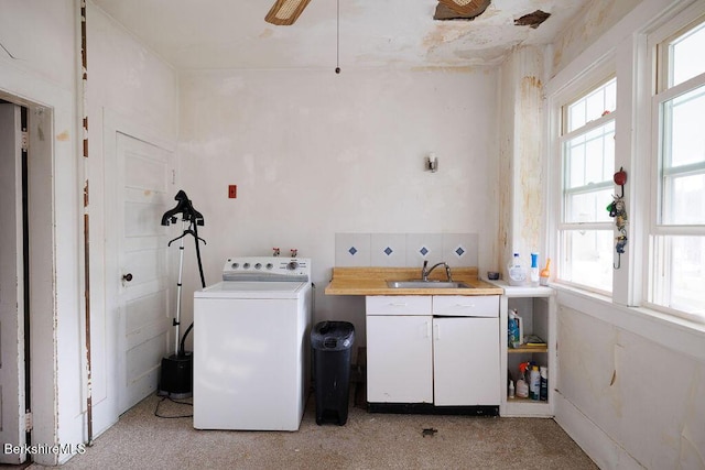 washroom featuring washer / clothes dryer, a sink, and cabinet space