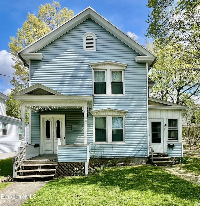 view of front of house with a porch, entry steps, and a front lawn