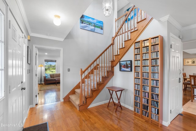 stairs featuring wood-type flooring and crown molding