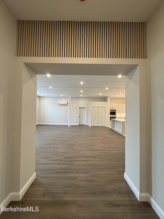 unfurnished living room featuring dark wood finished floors and baseboards